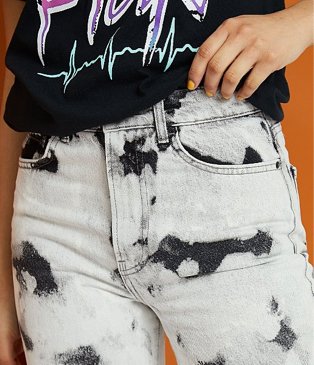 Close-up shot of woman's torso wearing G21 tie-dye denim jeans and G21 Pink Floyd black t-shirt.