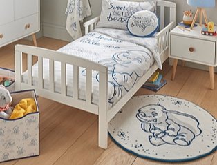 Bedroom features white bed topped with Disney Dumbo bedding, white side table, Disney Dumbo storage box and Disney Dumbo rug.