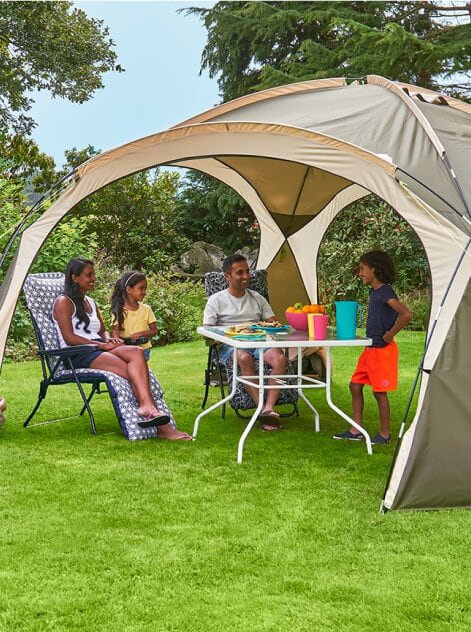 A family outdoors in a tent. 