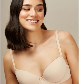 Woman poses smiling wearing nude 01 t-shirt bra.