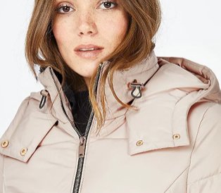 Woman in beige puffer jacket and black turtle neck top.