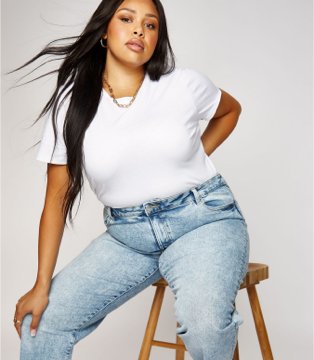 Woman wearing white t-shirt and faded denim jeans.
