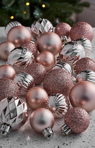 Speckled surface features silver-tone textured baubles, pink shiny baubles and pink glitter baubles.