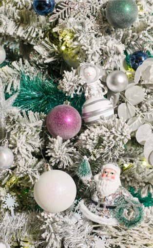 Artificial Christmas tree features Santa decorations and multicoloured baubles.