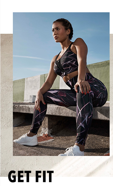 Kaz Crossley sitting on a stone bench outdoors wearing a patterned sports tank top and matching bottoms