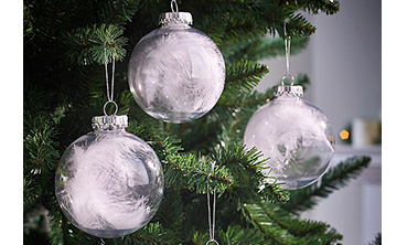 Baubles filled with white feathers hanging on a Christmas tree