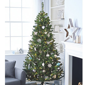 Christmas tree with blue and white baubles in a room with a white fireplace and star decoration 