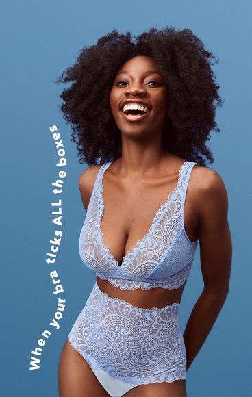 Woman poses smiling wearing light blue lace bralet and high waisted brief matching lingerie set.