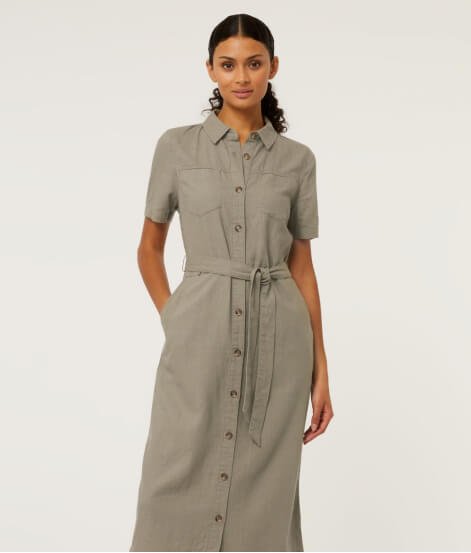 Woman poses wearing khaki linen blend midi shirt dress.