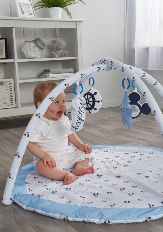 A baby playing in a Mickey Mouse play gym