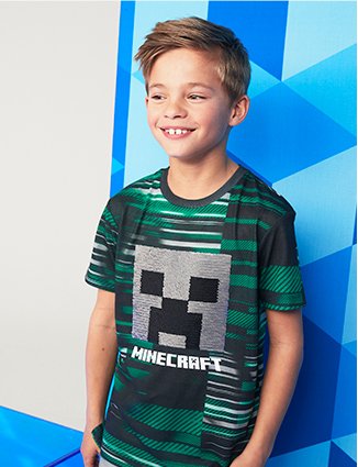 Boy poses smiling wearing Minecraft creeper green swipe sequin t-shirt.