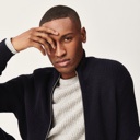 Man posing wearing grey jumper with a navy jacket