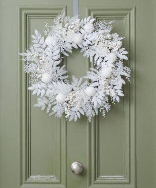 A white wreath on green door.