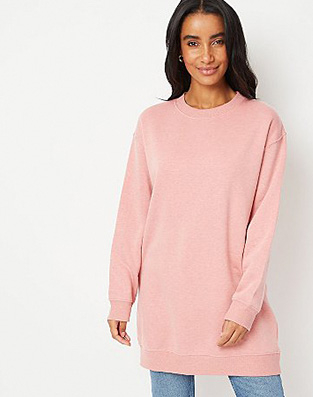 Woman in pink slouchy jumper and light blue jeans