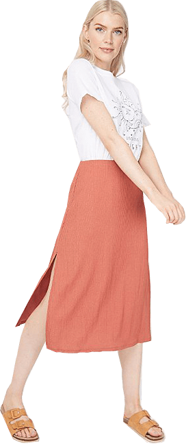 Woman wearing a tan textured midi skirt, white t-shirt and tan sandals