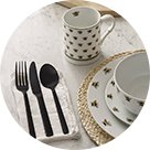 White Bumble Bee Pattern Dinner Set on natural tablecloth, wicker placemats and Matt Black Cutlery Set.