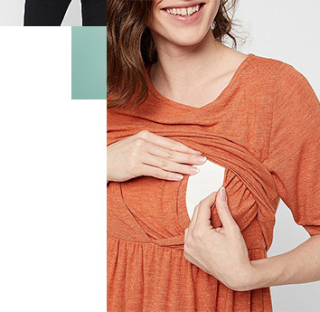 Woman wearing an orange peplum nursing top lifting the upper layer to demonstrate the nursing feature