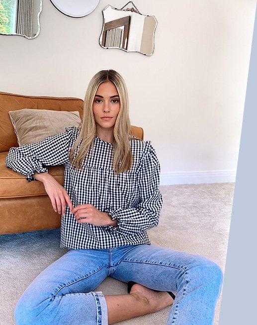 Model Meg wearing a blue and white stripped blouse with blue jeans