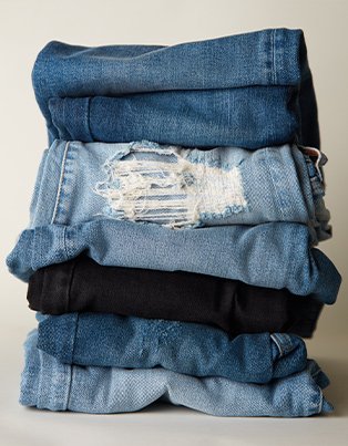 Stack of light wash, medium wash, dark wash and black jeans.