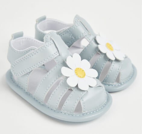 Baby sandals with a flower on the front.