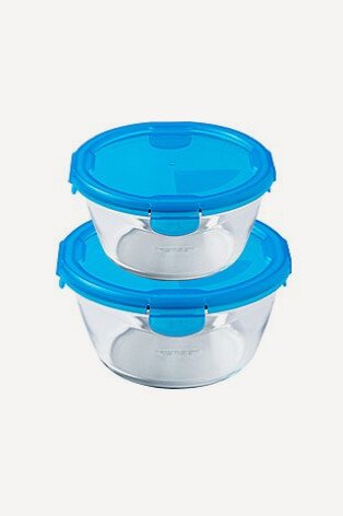 Two round pyrex storage containers with blue clip lids stacked on top of each other