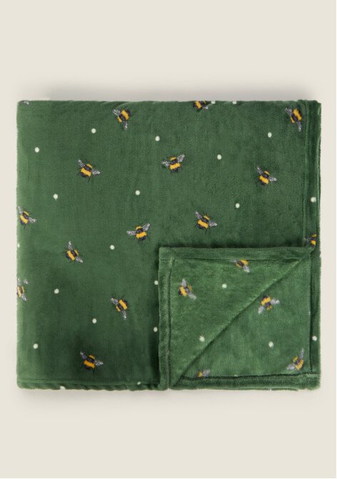 A green, bee patterned throw.
