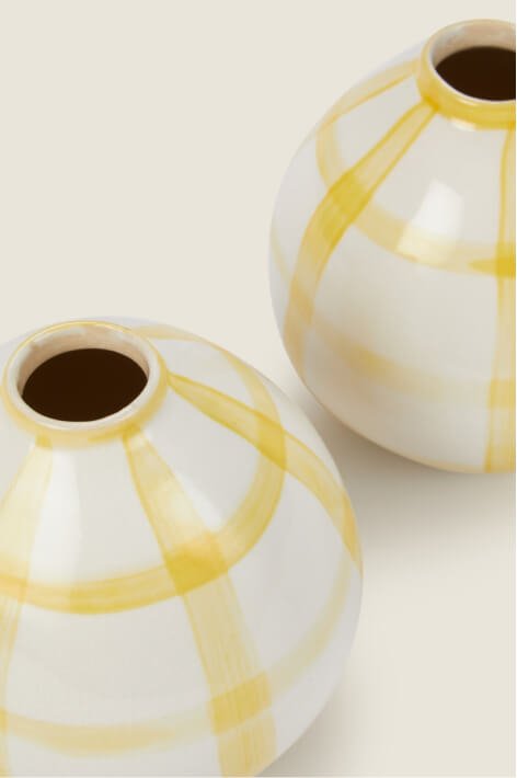 A set of two yellow patterned vases.