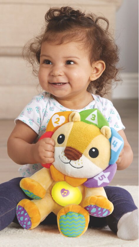 A child playing with a LeapFrog lullaby lights lion toy.