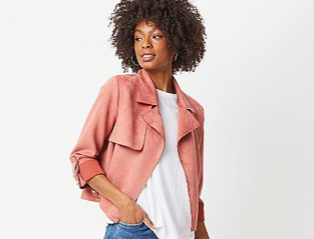 Woman wearing a pink faux suede biker jacket over a white T-shirt and jeans