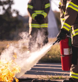 A firefighter putting out a fire with a fire extinguisher