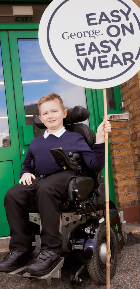 A boy wearing school uniform, holding an easy on easy wear sign.