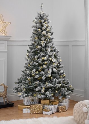 6ft pre-lit snowy pine Christmas tree with presents underneath next to white mantelpiece with gold light-up star.