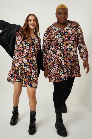 Two women wearing matching floral dresses.