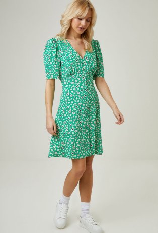 Woman wearing pastel green floral knee length dress.