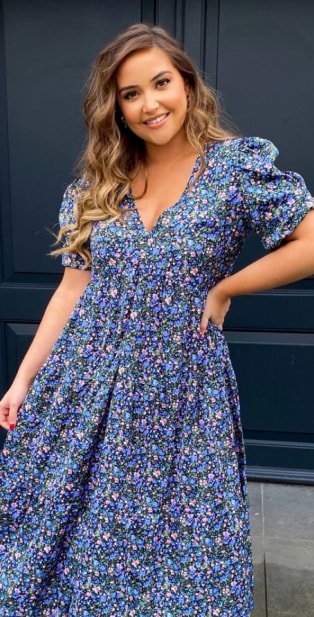 Woman wearing knee length floral dress.