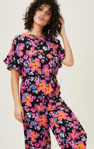 Woman wearing floral jumpsuit.