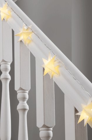 White paper star string lights on a white banister