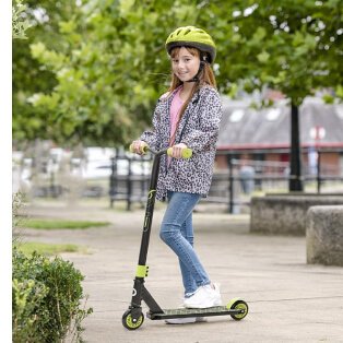 A girl playing with a scooter wearing a matching helmet.