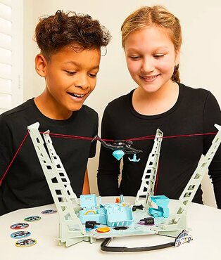 Two children playing a halloween game wearing long sleeved black tops.