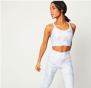 Woman wearing matching white sports bra and sports leggings