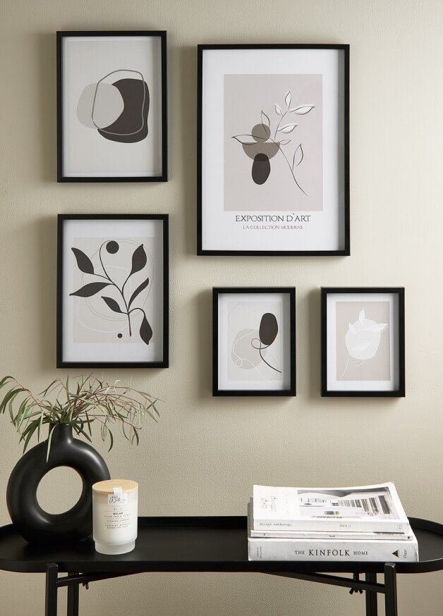 A gallery wall with monochrome prints in black frames.
