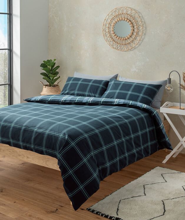 A double bed with a blue check duvet set.