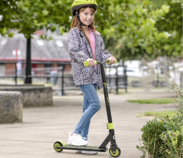 A girl using a lime green and black EVO Viper Stunt Scooter.