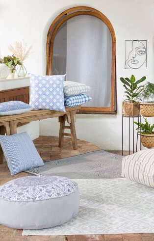 Bright living room with wooden furniture with light blue cushions and light colored rugs