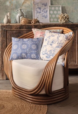 Wooden chair with cream seat cushion features an assortment of printed scatter cushions.