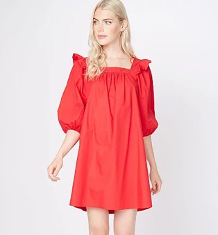 Woman poses wearing red balloon sleeve mini smock dress with frill shoulder detailing.