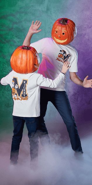 An adult and child wearing matching Mickey Mouse Halloween tops and pumpkin heads