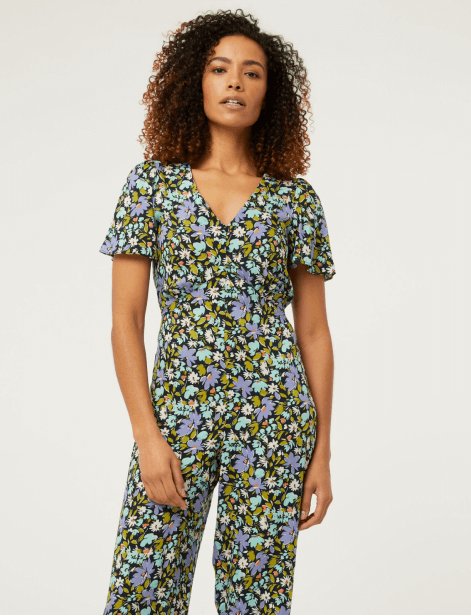 A woman wearing a floral jumpsuit