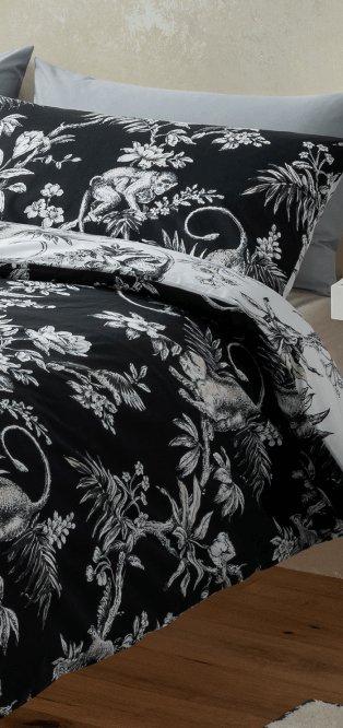 A black floral duvet set on a double bed.