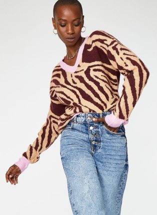 Woman wearing zebra print jumper and jeans.